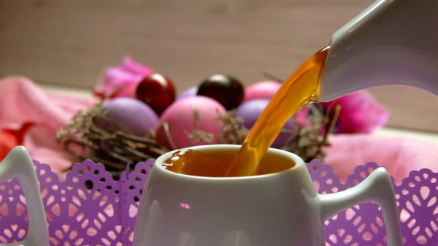 Colored-pink-Easter-egg-lies.-Tea-poured-in-the-cup