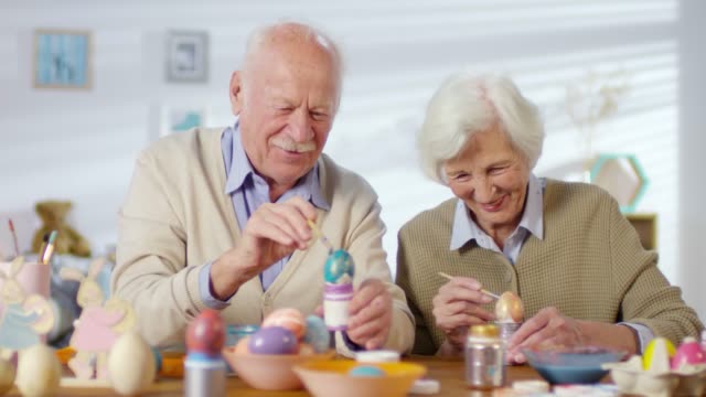 Couple-Smiling-and-Laughing-when-Painting-Eggs