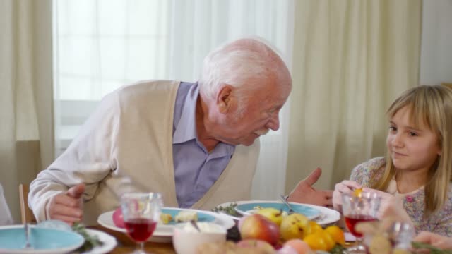 Großvater-spricht-mit-Enkelkindern-beim-Family-Dinner