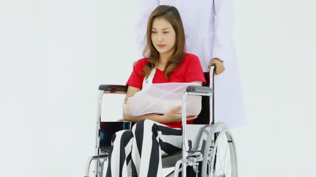 Doktor,-der-den-Rollstuhl-drückt,-darauf-sitzt-die-Frau.