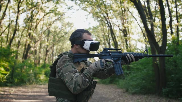 Soldat-mit-Gewehr-trägt-Virtual-Reality-Brille-im-Freien