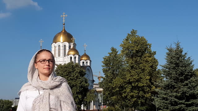 Orthodoxe-Lifestyle-Frau-im-Schal-steht-auf-dem-Hintergrund-der-orthodoxen-Kirche