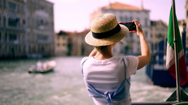 Glücklich-lächelnde-weibliche-Reisende-schwimmen-auf-touristischen-Boot-rund-um-Venedig-Stadt-machen-Video-für-die-Schaffung-von-Veröffentlichung-in-sozialen-Netzwerk