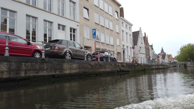 Bruges,-Belgium---May-2019:-View-of-the-water-channel-in-the-city-center.-Tourist-walk-on-the-water-canals-of-the-city.-View-from-a-tourist-boat.