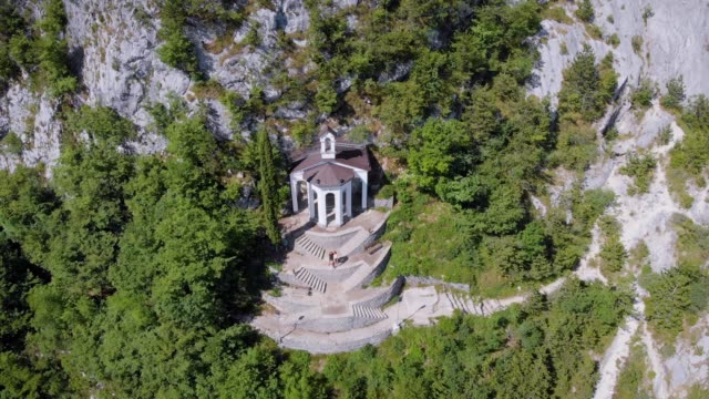 aerial-shot-of-amazing-house-inside-cliff-in-italian-mountains-in-sunny-summer-day,-view-from-birds-eye