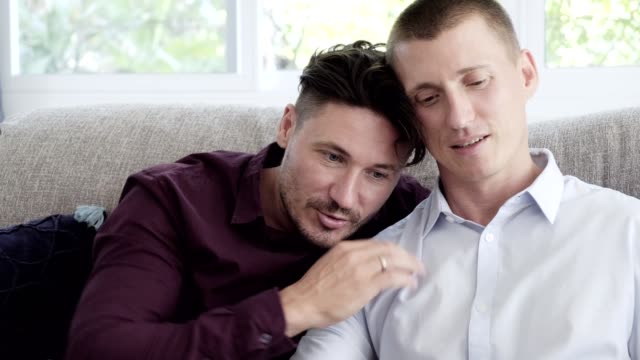 Gay-couple-relaxing-on-couch.-Lean-on-shoulder.
