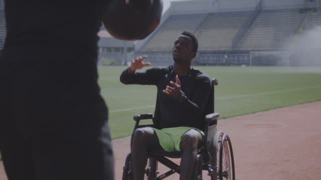 Wheelchaired-athlete-and-trainer-throwing-medicine-ball