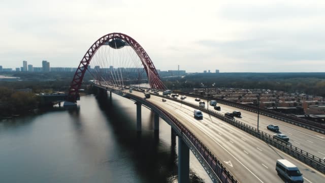 Aerial-view-of-modern-cable-stayed-bridge-through-the-Moscow-river-with-moving-cars-against-cloudy-sky.-Scene.-Moscow-skyline-in-summer