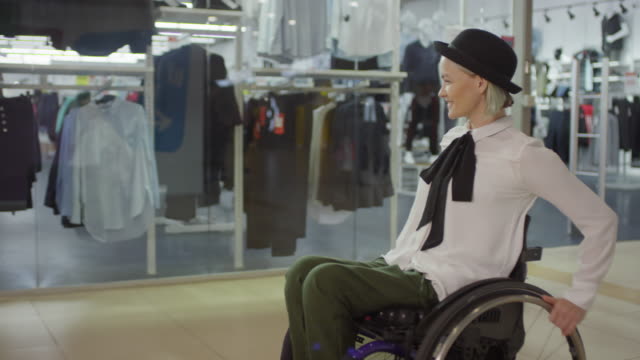 Glückliche-behinderte-Frau-im-Rollstuhl-Reiten-durch-Mall