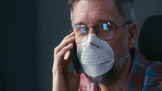 Man-in-face-mask-having-phone-call