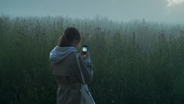 Girl-take-photos-of-morning-fog-in-the-grassland