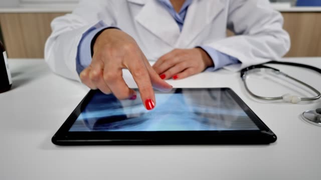 female-doctor-checking-chest-lung-xrays-on-tablet-dolly-shot