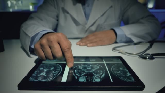 männlicher-Arzt-mit-Tablette,-um-Röntgen-Gehirn-mri-zu-analysieren