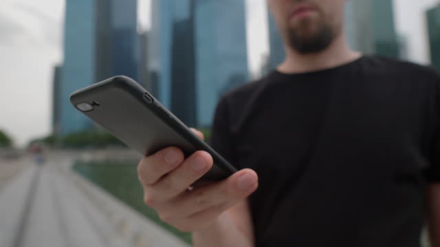 Unbekannter-Reisender-SMS-auf-Smartphone-auf-der-Straße-einer-Großstadt