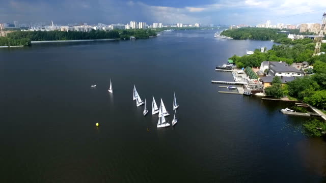 Shooting-bird's-eye.-Flying-drone-slowly-flying-over-blue-water.-Beautiful-hotel-on-the-banks-of-the-river.-Yacht-dock.4k-resolution.-Calm
