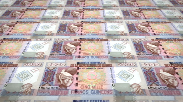 Banknotes-of-five-thousand-guinean-francs-rolling,-cash-money,-loop