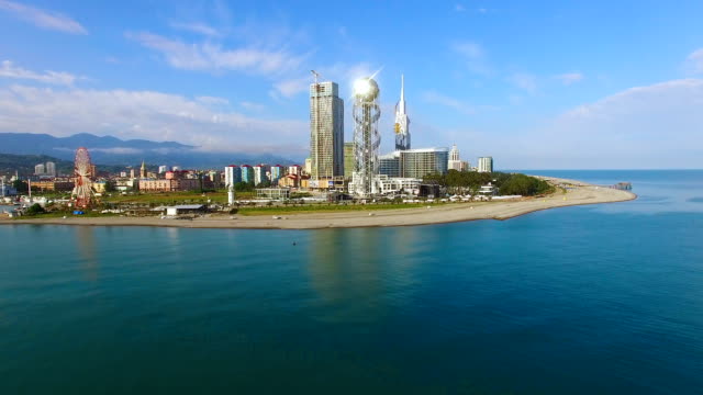 Alphabetic-tower-in-Batumi-standing-across-sea,-crystal-ball-reflecting-sunshine