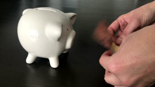 Frau,-eine-zehn-Euro-Banknote-in-ein-Sparschwein