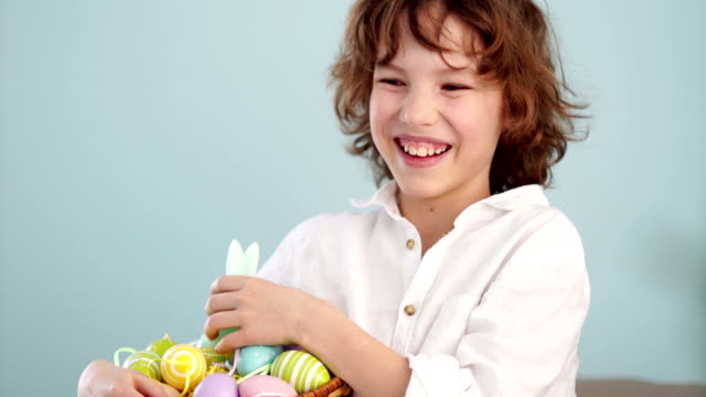 Klaus-ap-portrait-of-a-curly-red-haired-boy-with-a-basket-of-Easter-eggs-in-his-hands.-Happy-easter