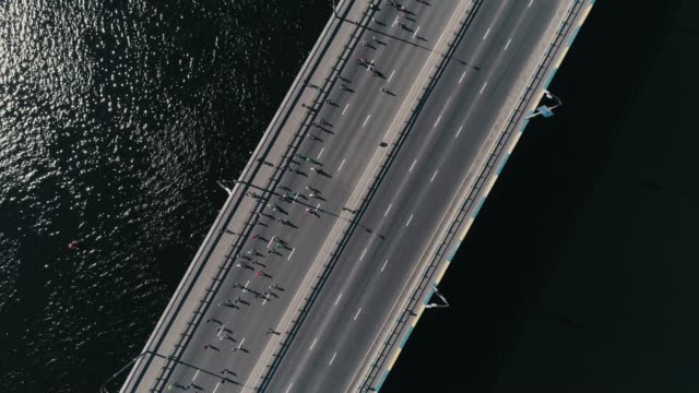 4K-Luftbild-Drohne-Fooage.-Marathonlauf-auf-der-Brücke.-Kamera-drehen,-Ansicht-von-oben