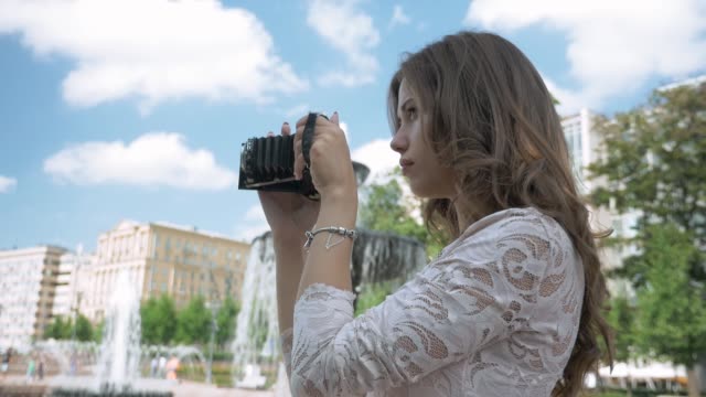 Schöne-Mädchen-nimmt-Fotos-der-Sehenswürdigkeiten-der-Stadt,-auf-eine-Vintage-Kamera