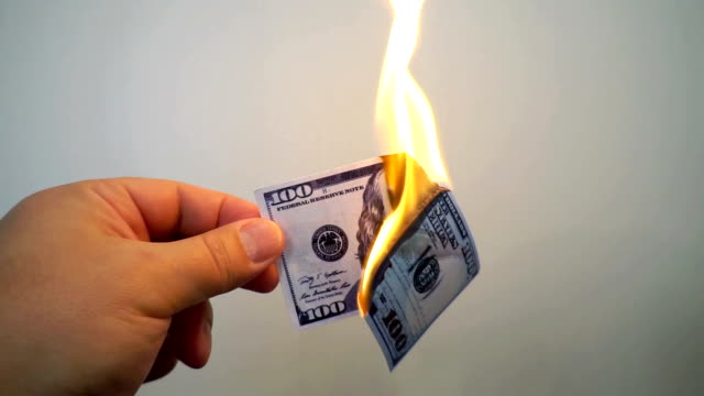 Hand-mit-einer-brennenden-hundert-Dollar-banknote