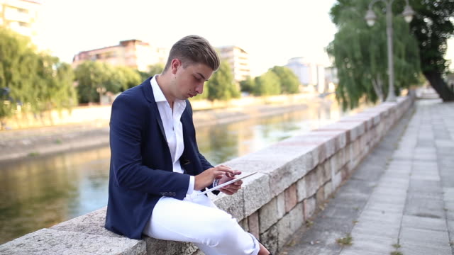 Young-man-using-tablet-outdoors