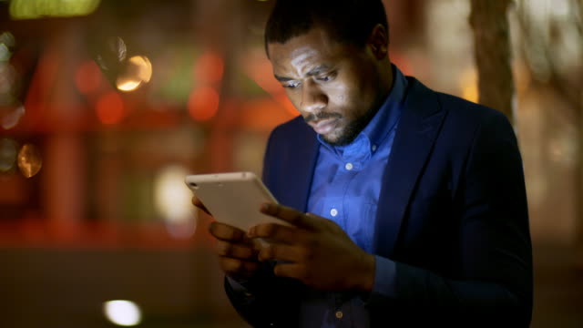 Hombre-africano-usando-tableta-al-aire-libre