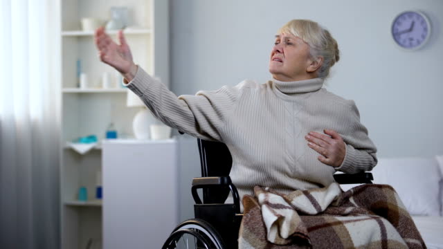 Alte-Dame-im-Rollstuhl-Herz-Schmerz-zu-empfinden,-Pillen,-Krankenhausversorgung-Krankenschwester-fordern