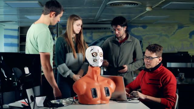 Equipo-de-ingenieros-está-teniendo-una-discusión-sobre-un-robot-de-apariencia-humana
