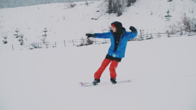 Männlicher-Snowboarder-fährt-auf-einem-Brett-im-Schnee-von-der-Skipiste