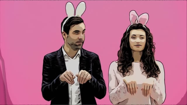 Young-couple-standing-standing-on-pink-background.-During-this-time,-they-are-dressed-in-rabble-ears.-Looking-at-each-other,-talk-and-smile.-Easter-Concept.