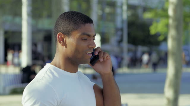 Smiling-African-American-sportsman-talking-on-smartphone.