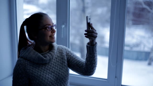 Caucasian-woman-uses-smartphone,-phone-screen-is-reflected-in-glasses-social-network,-technology,-communication-concept.