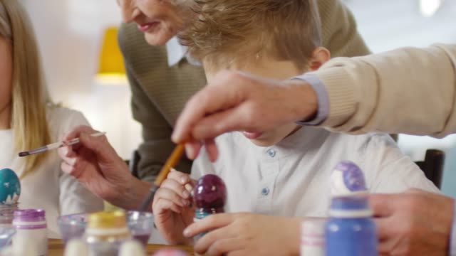Family-Talking-and-Smiling-while-Painting-Eggs