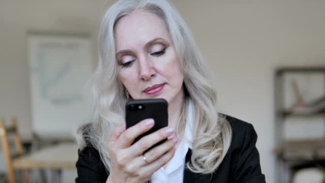 Businesswoman-Using-Smartphone-at-Work