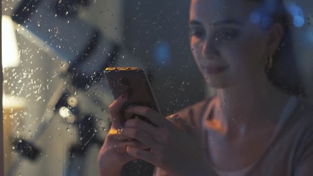 Smiling-girl-texting-with-her-phone-at-night
