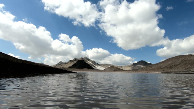 Timelapse-desfiladeros-acantilados-y-lago-de-montaña-con-sombras-en-movimiento-cielo