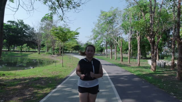 Asian-women-jogging-in-the-street-in-the-early-morning-sunlight-in-garden.-concept-of-losing-weight-with-exercise-for-health.