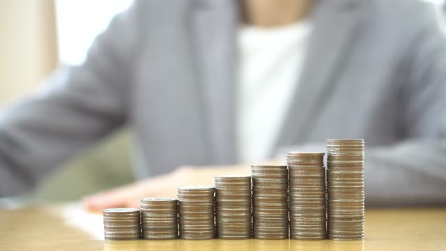 Close-up-Of-woman-Hand-Put-Coins-To-Stack-Of-Coins