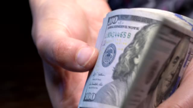 closeup-hand-shuffles-new-hundred-dollar-bills