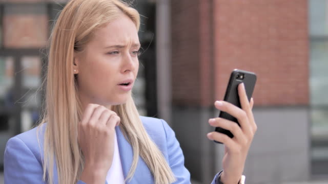 Outdoor-Junge-Geschäftsfrau-reagiert-auf-Verlust-auf-Smartphone