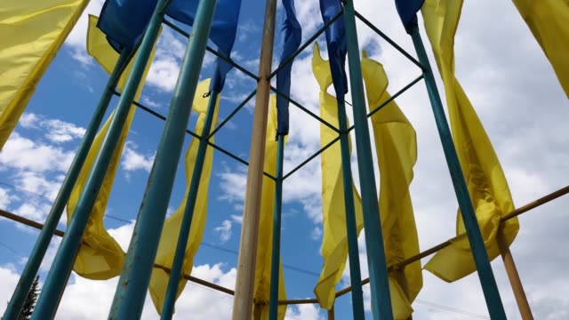 Ukrainische-Flaggen-flattern-im-Wind-gegen-einen-blauen-Himmel.-Helle-gesättigte-gelb-blaue-Farben.