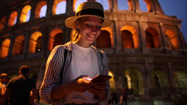 Glückliche-junge-Millennial-weibliche-Touristlesen-Textnachricht-per-App-auf-Smartphone-zufrieden-mit-Roaming-Internetverbindung