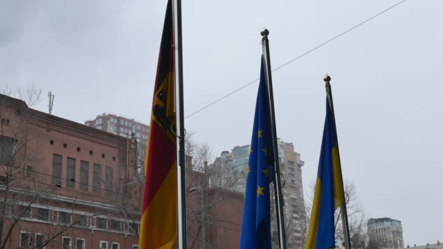 three-flags-waving-on-poles---EU,-DE-and-UA