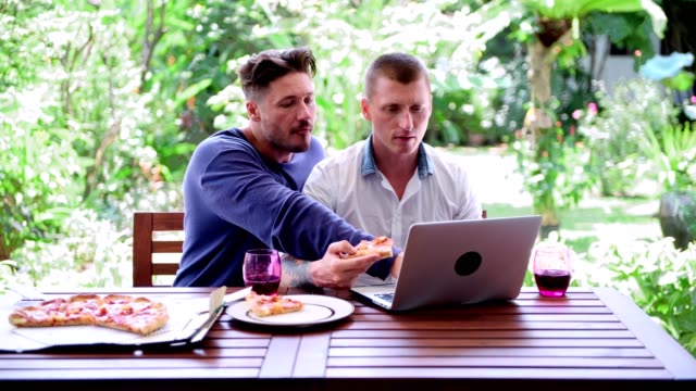 Gay-couple-having-pizza-for-lunch.-Small-argument.