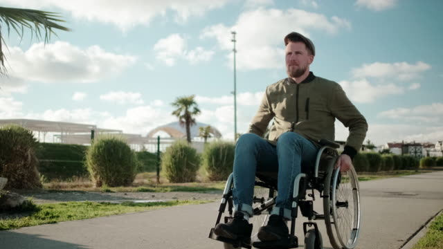 Man-with-paralysis-of-legs-muscles-is-sitting-in-invalid-carriage-and-riding
