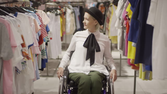 Happy-Handicapped-Woman-in-Wheelchair-Shopping-for-Clothes