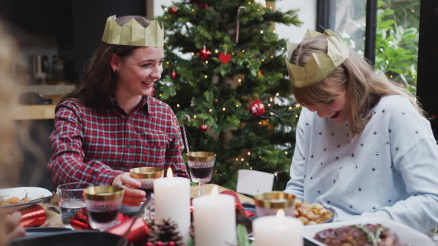 Schwules-weibliches-Paar-sitzt-um-Tisch-für-Weihnachten-Abendessen-zusammen