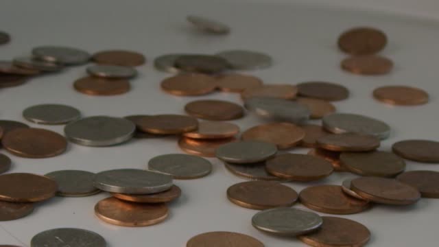 Super-Zeitlupe-eines-Haufens-von-Münzen,-die-auf-einen-Tisch-fallen